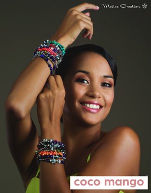 A smiling woman poses showcasing colorful beaded bracelets on both wrists, against a gray background, with "coco mango" text at the bottom