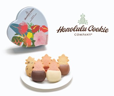 Different flavors of pineapple-shaped cookies next to a blue heart-shaped tin with various flora.