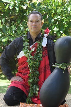 Kumu Blaine Kia posing with a large ipu (gourd-shaped instrument).