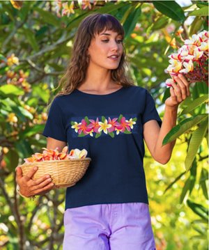 Woman picking plumeria flowers wearing a shirt with similar flowers on it from Crazy Shirts
