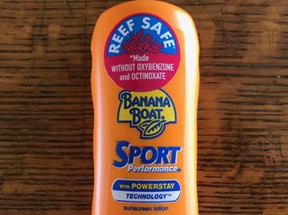 Orange bottle of Banana Boat sport sunscreen marked with a Reef Safe sticker