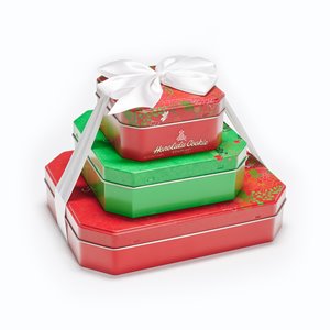 Set of 3 stacked Honolulu Cookie Company Mele gift tins wrapped with a white ribbon