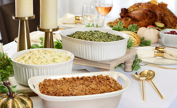 Ruth's Chris Steak House Thanksgiving spread with bowls of side dishes and a whole turkey.