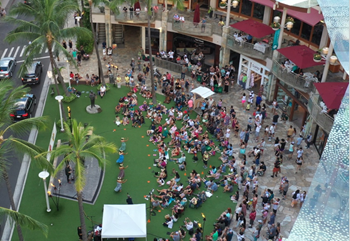 Drone shot of Waikiki Beach Walk lawn area filled with people