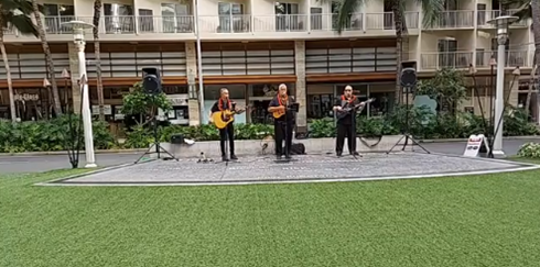 Ku Haaheo livestream screenshot showing 3 men with guitars performing Hawaiian music.