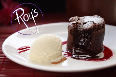 Souffle gushing chocolate with an ice cream scoop & raspberry coulis.