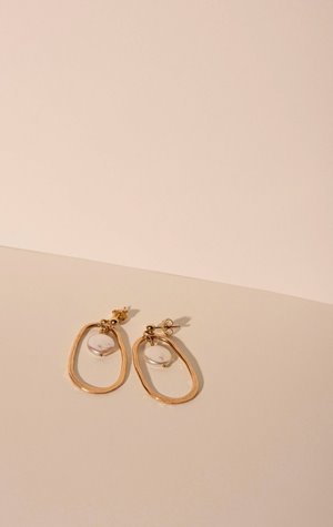 2 gold oval-shaped earrings with a pearl charm in the middle from Oasis by Kolohe as part of the limited edition Mother's Day collection
