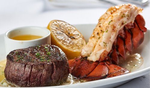 Filet steak, lobster tail, butter, & a lemon wedge on a sizzling plate at Ruth's Chris Steak House in Waikiki