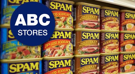 3 rows of various SPAM cans stacked together next to the ABC Stores logo