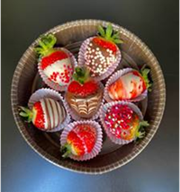 Bowl with an assortment of chocolate-dipped strawberries in various patterns & toppings.