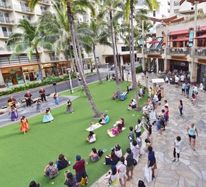 Hawaiian music show taking place in front of an audience on the lawn in Waikiki