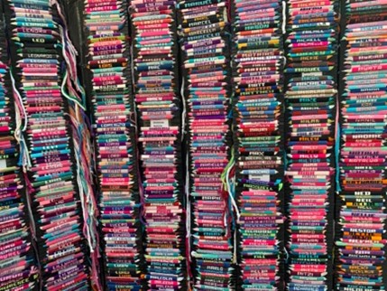 Rows of multicolored woven bracelets with names on them by Names All Day, a vendor at Waikiki Beach Walk's farmers market.