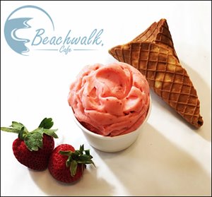Strawberry gelato in a cup next to strawberries and a waffle cone.jpg