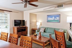 Living area of a suite at Club Wyndham at Waikiki Beach Walk featuring sofa, dining table, coffee table, television, etc.