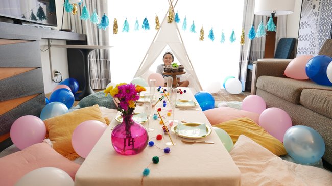 Suite living area with colorful balloons & tent decorations as part of the hotel's keiki glamping for kids activity.