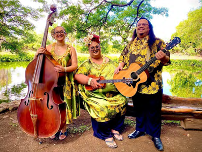 Musical trio in matching aloha wear holding a cello, ukulele, and guitar.