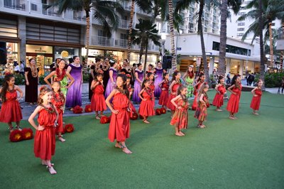 Troupe of hula dancers in red and purple