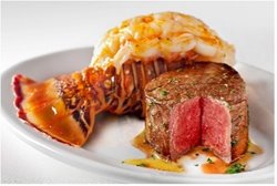 Steak and lobster tail on a white plate