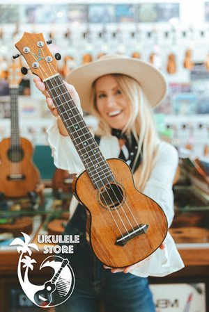 Girl wearing a hat holding a ukulele with text that reads "ukulele store"