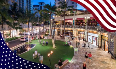 Waikiki Beach Walk storefronts with American flag framing