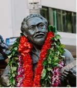 Closeup of Gabby Pahinui statue adorned with colorful lei